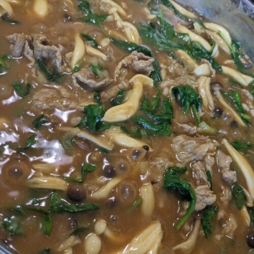 simmering pot of Japanese curry with shabu shabu meat spinach and mushrooms