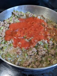 tomato sauce and seasonings added to pan with ground beef and vegetables for sloppy joes