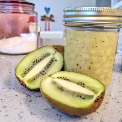 jar of kiwi ginger salad dressing next to kiwi cut in half