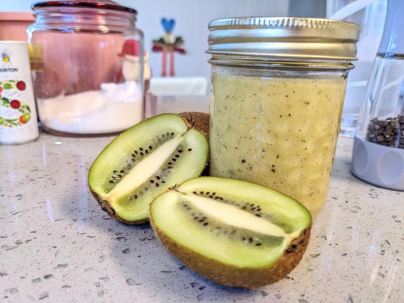 jar of kiwi ginger salad dressing next to kiwi cut in half