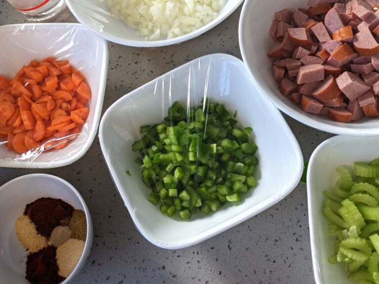 photo of ingredients for slow cooker pinto beans and sausage: carrots, onions, green bell peppers, celery, sausage, spices