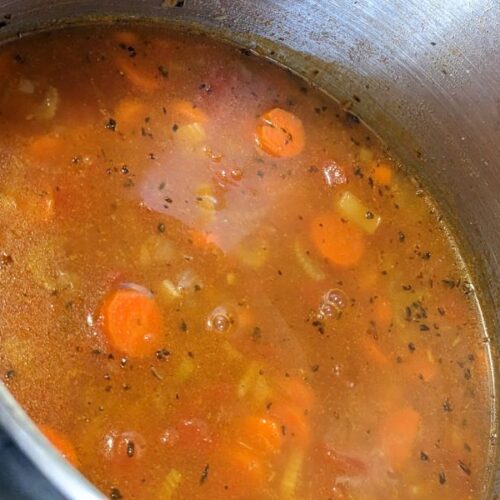 pot of vegetable soup with onions, carrots, celery, tomatoes and pasta