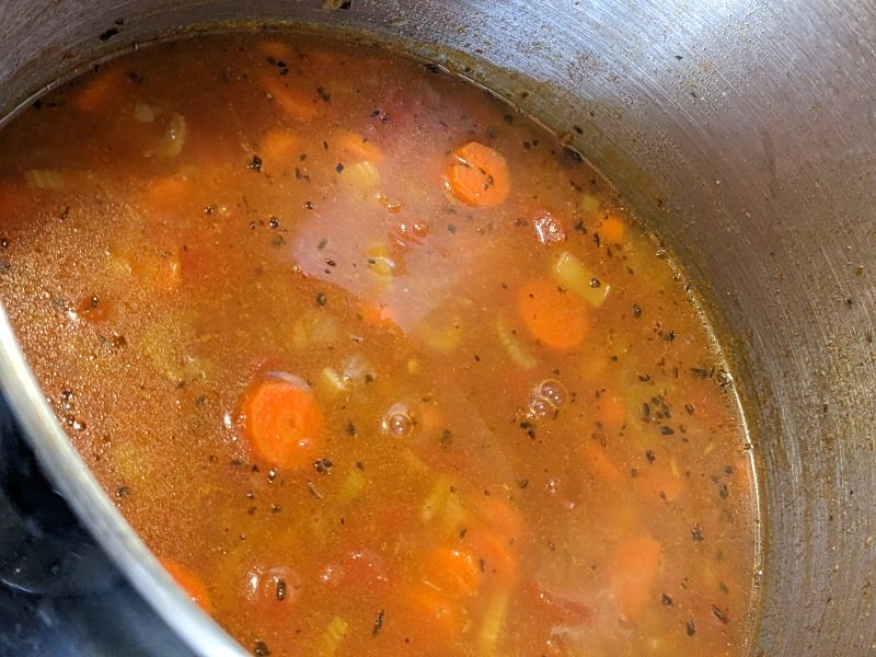 pot of vegetable soup with onions, carrots, celery, tomatoes and pasta