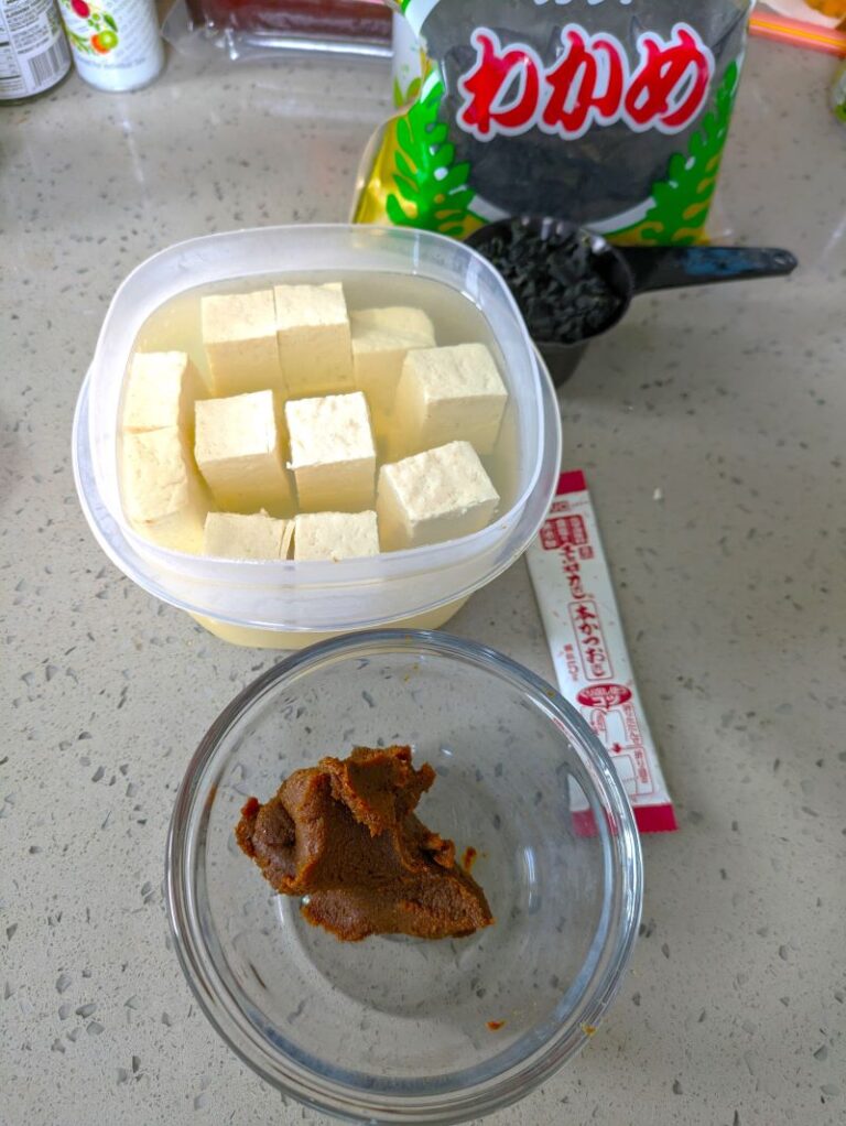 red miso paste in a bowl and a bowl of tofu