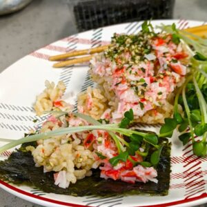 plate with a serving of sushi rice casserole with imitation crab, radish sprouts, and roasted seaweed