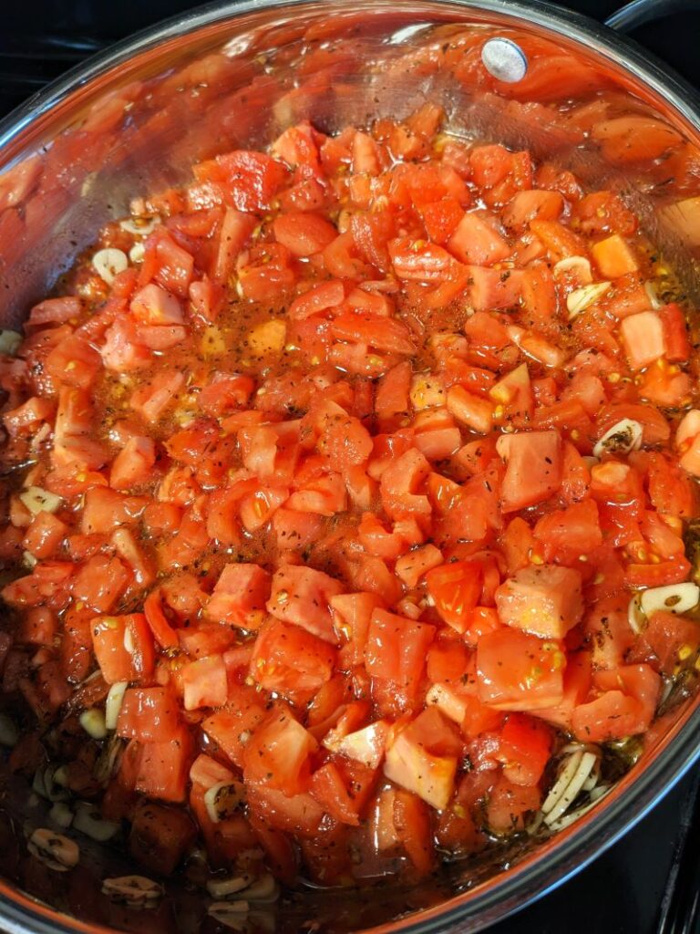 chopped Roma tomatoes in pan to cook fresh tomato pasta sauce