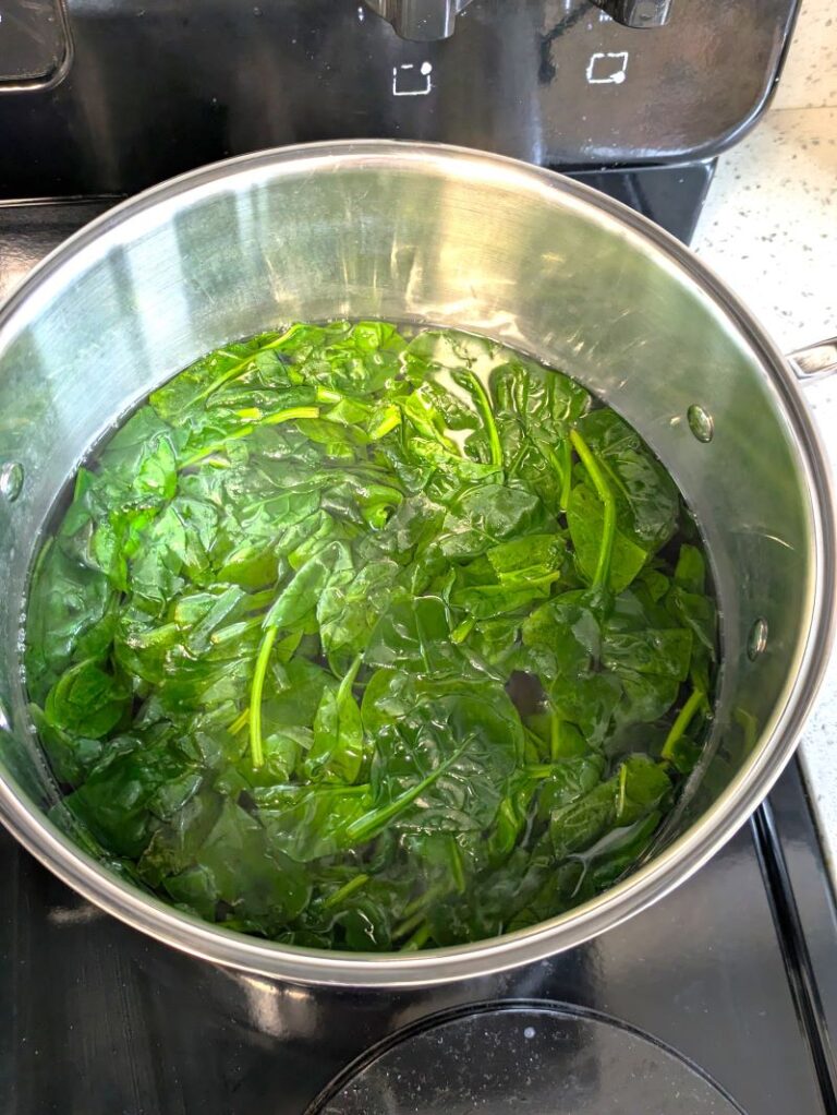 spinach being blanched in a pot